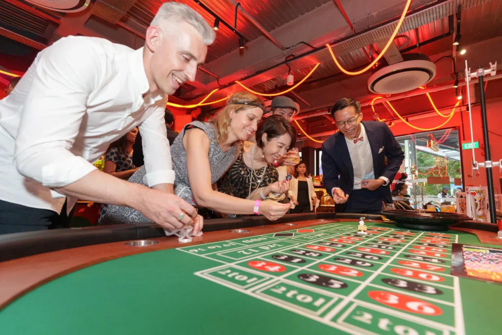 Guests enjoying a hosted table activity at a corporate year-end party in Singapore