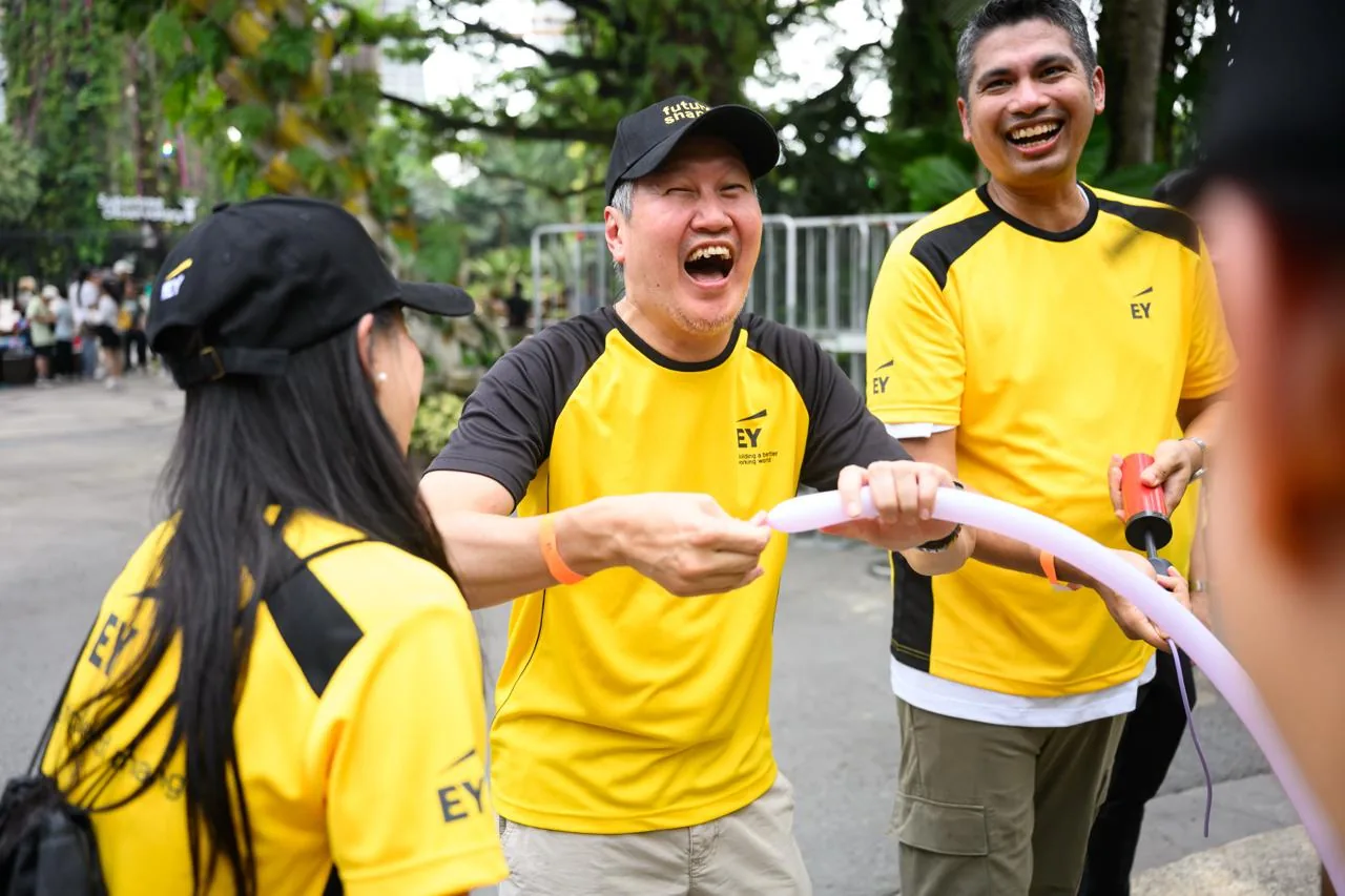 Colleagues laughing together during an outdoor team-building balloon activity